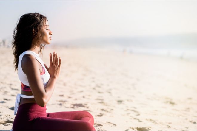 Woman meditating beach Woman meditating beach